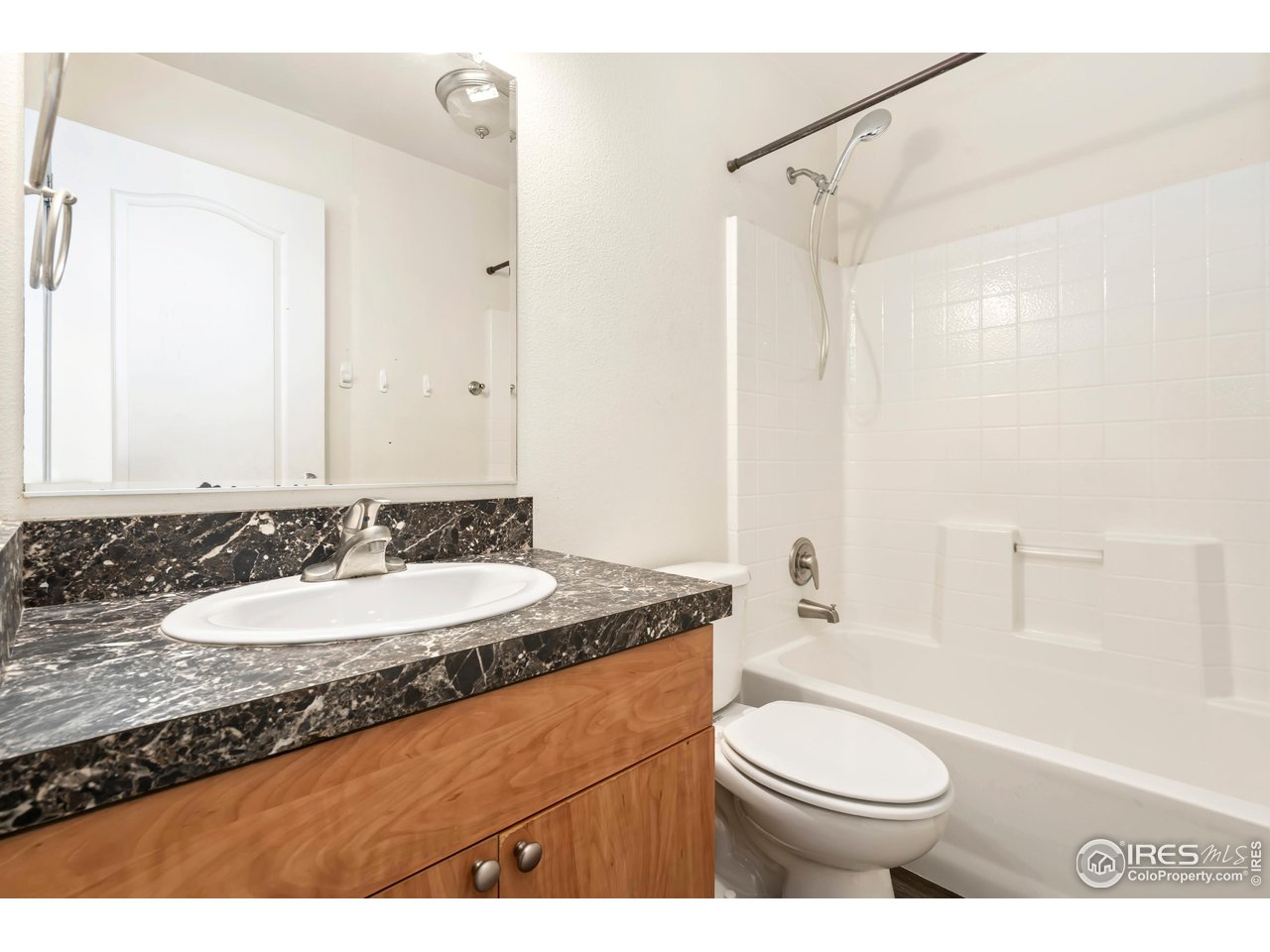 4324 Buffalo Trail Evans, CO 80620 - Photo 16 of 16 a bathroom with a granite countertop sink toilet a mirror and shower
