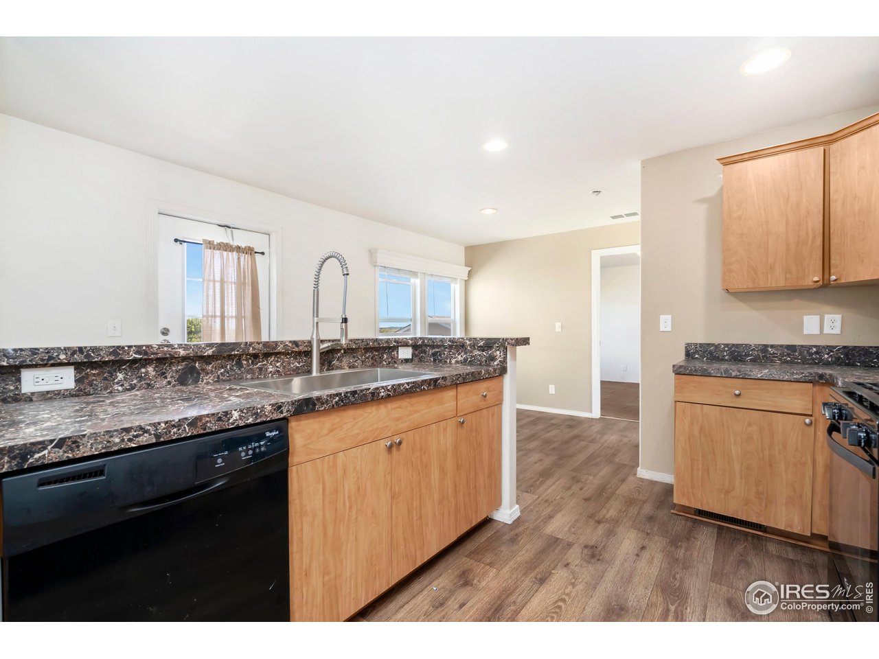 4324 Buffalo Trail Evans, CO 80620 - Photo 5 of 16 a kitchen with granite countertop a sink stove and cabinets