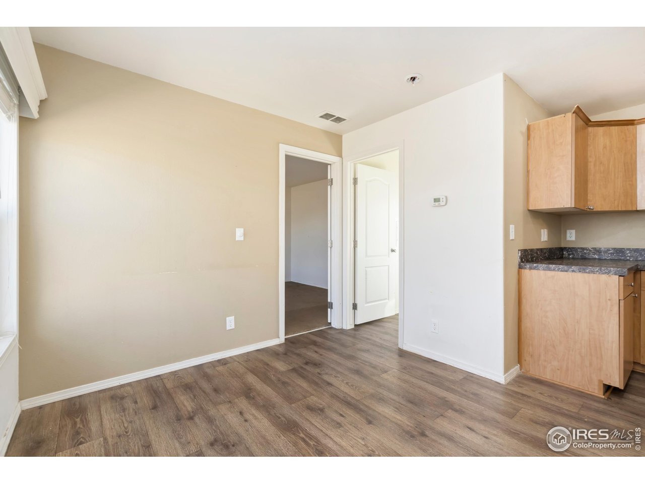 4324 Buffalo Trail Evans, CO 80620 - Photo 8 of 16 a view of an empty room with wooden floor