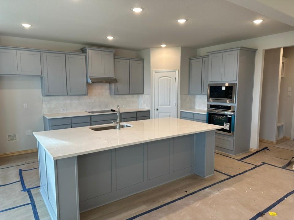 210 Horizon Rd Valley View Valley View, TX 76272 - Photo 7 of 23 Kitchen featuring light gray shaker cabinetry, stainless steel appliances, a center island with sink, recessed lighting, and a patterned tile backsplash