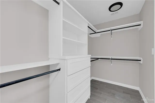 a view of walk in closet with empty racks