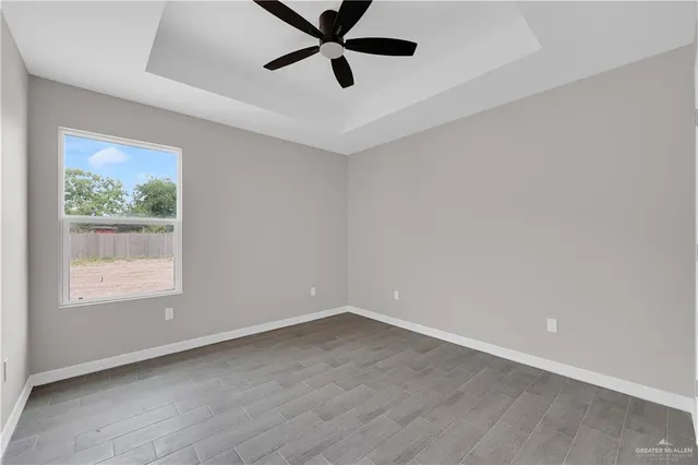 an empty room with a window and a ceiling fan
