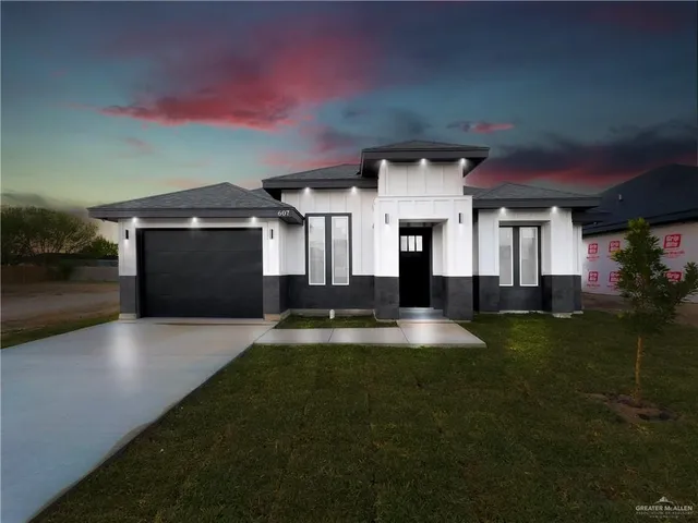 a front view of a house with a yard and garage