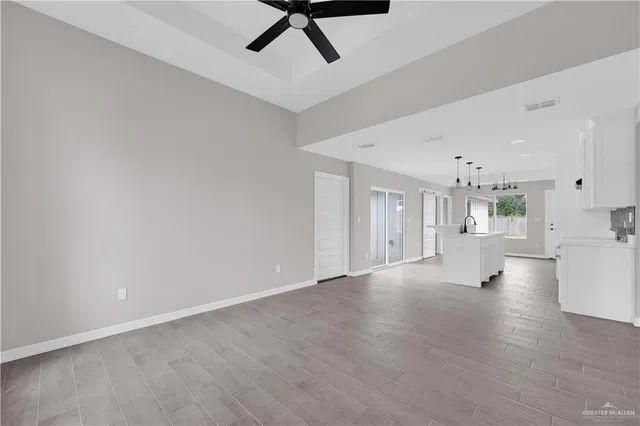a view of a big room with wooden floor and windows