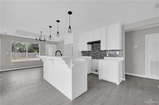a view of living room with stainless steel appliances kitchen island hardwood floor and living room view