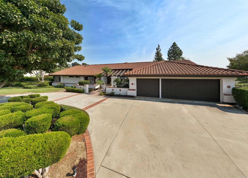 a front view of a house with a yard and potted plants