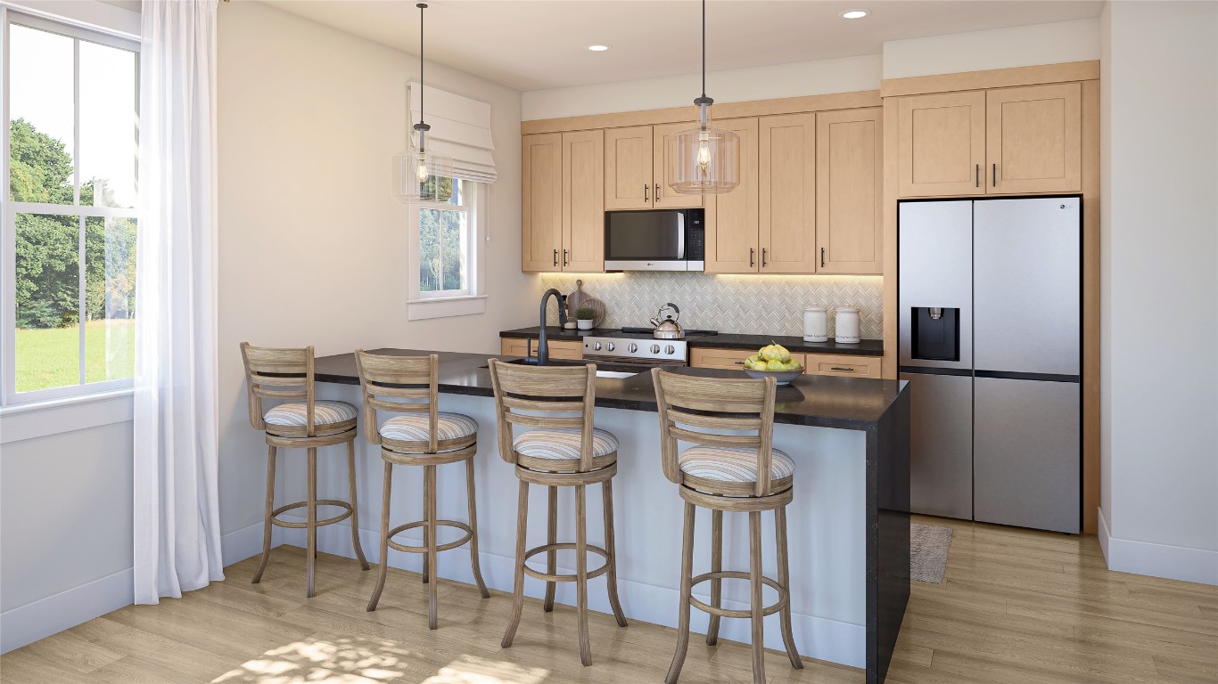 2420 Drew, Unit 6 Austin, TX 78748 - Photo 3 of 7 Kitchen featuring a peninsula, a kitchen breakfast bar, appliances with stainless steel finishes, hanging light fixtures, and backsplash