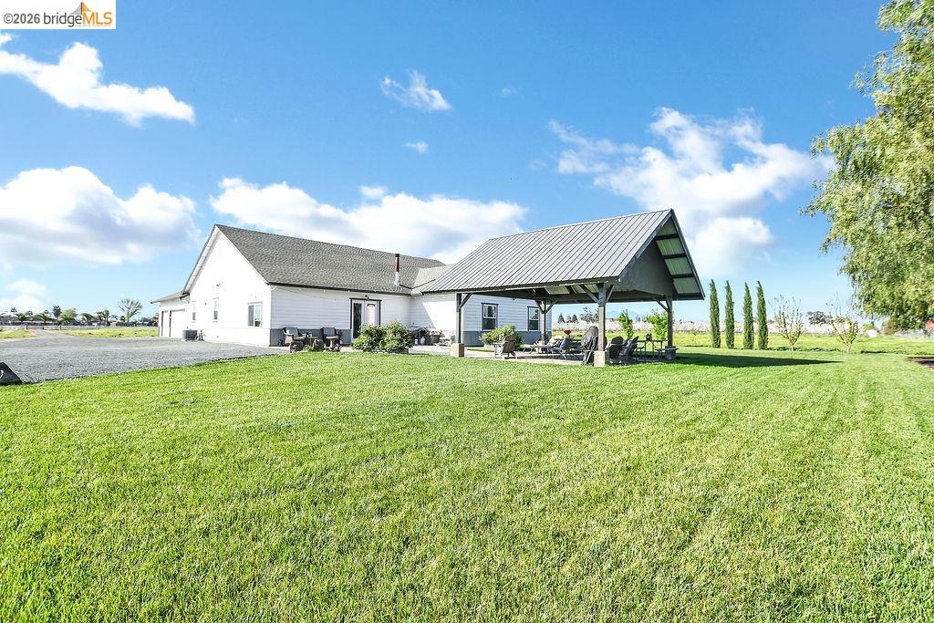 2200 Delta Road Knightsen, CA 94548 - Photo 21 of 26 Back of house featuring a patio area, a yard, and a metal roof