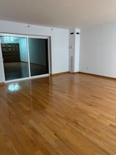 a view of an empty room with wooden floor