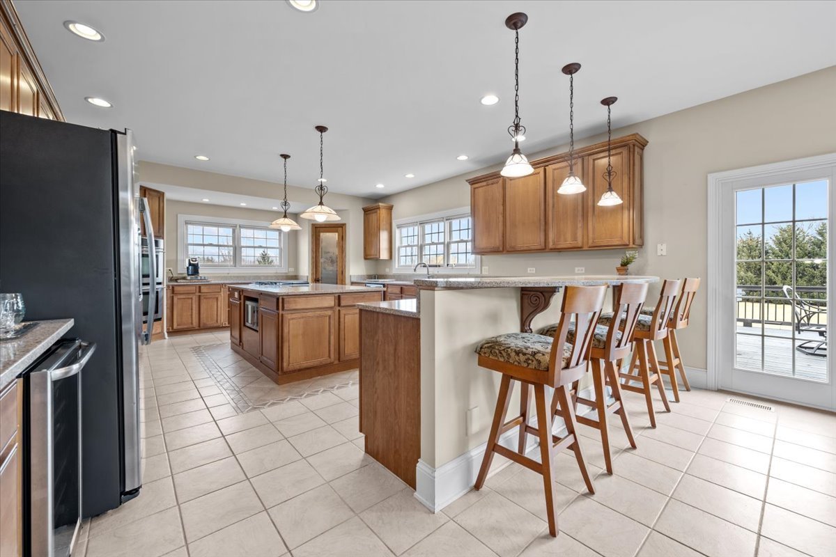 1-n203 East Blackberry Crossing Circle Elburn, IL 60119 - Photo 11 of 30 a kitchen with stainless steel appliances granite countertop a stove top oven a refrigerator a sink and a island