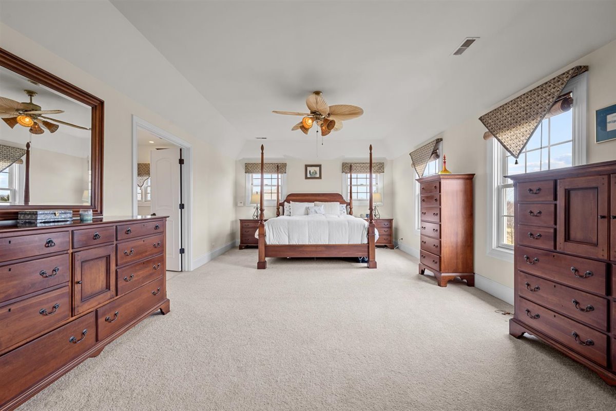1-n203 East Blackberry Crossing Circle Elburn, IL 60119 - Photo 20 of 30 a spacious bedroom with a bed and a chandelier