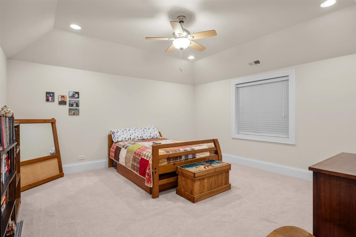 1-n203 East Blackberry Crossing Circle Elburn, IL 60119 - Photo 27 of 30 a room with a bed and a chandelier