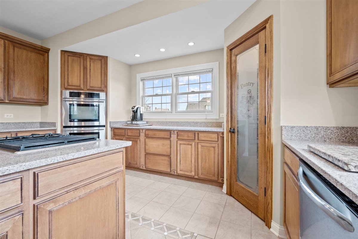 1-n203 East Blackberry Crossing Circle Elburn, IL 60119 - Photo 10 of 30 a kitchen with stainless steel appliances granite countertop a stove a sink and a refrigerator