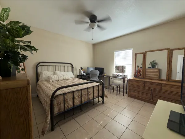 a spacious bedroom with a bed and a chandelier