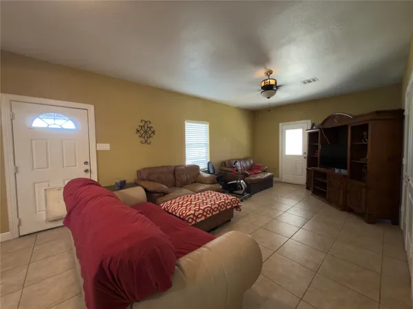 a living room with furniture a flat screen tv and kitchen view