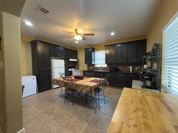 a large kitchen with a table and chairs