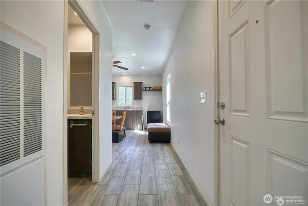 a view of a hallway with wooden floor and windows