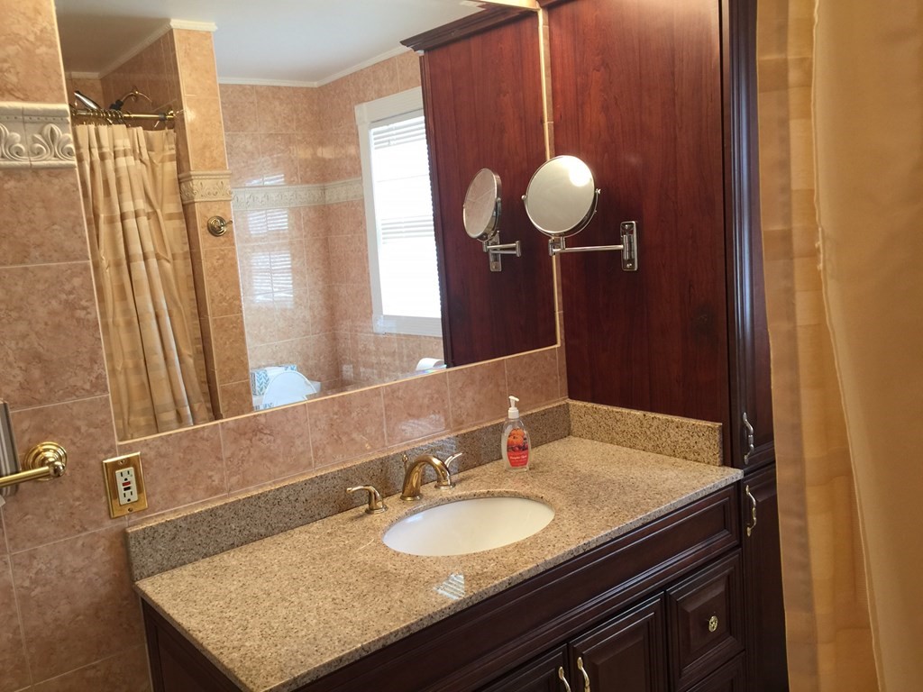 40 Niles Road Randolph, MA 02368 - Photo 23 of 29 a bathroom with a granite countertop sink a mirror and shower