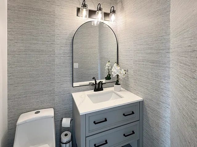 a bathroom with a sink a toilet and mirror