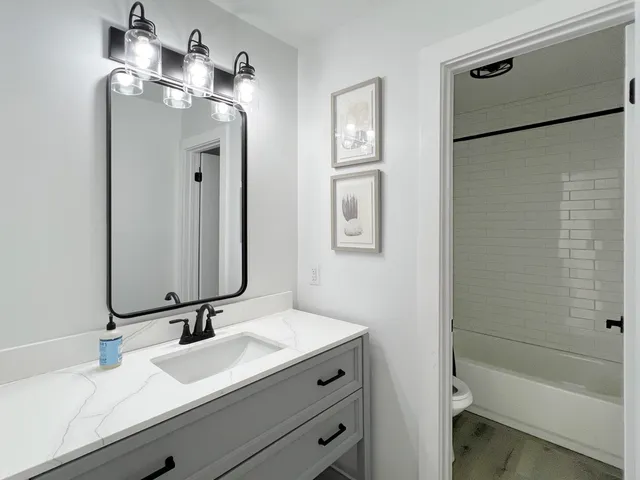 a bathroom with a double vanity sink mirror and shower
