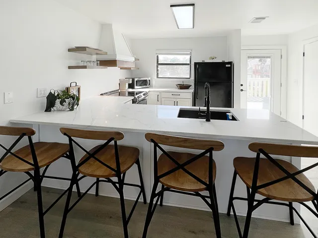 a kitchen with stainless steel appliances kitchen island wooden cabinets and chairs