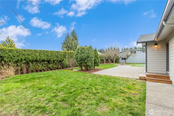 a backyard of a house with table and chairs