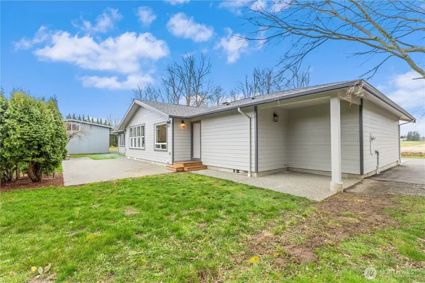 a view of a house with a yard and tree s