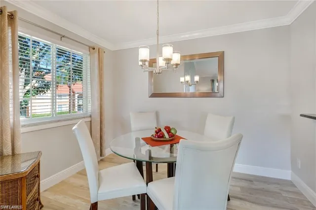 a dining room with furniture a chandelier and wooden floor