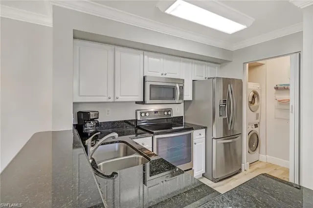 a kitchen with a refrigerator sink and cabinets
