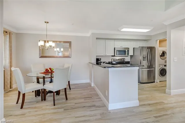 a kitchen with refrigerator and wooden floor