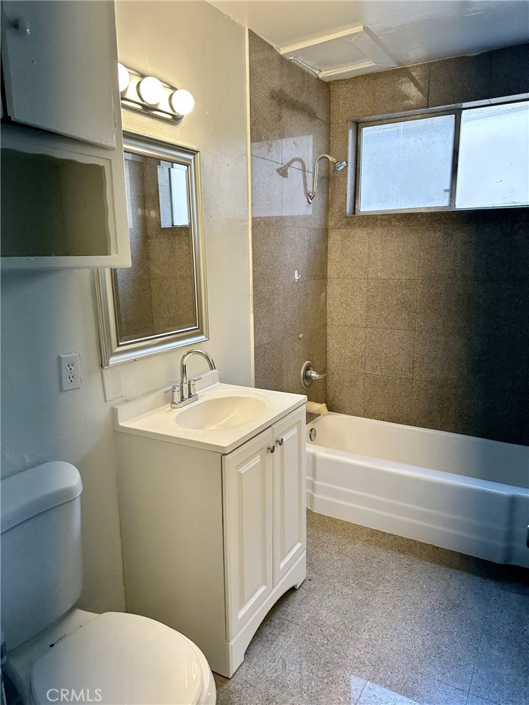 4830 Canoga Street, Unit E Montclair, CA 91763 - Photo 6 of 8 a bathroom with a sink a toilet and bathtub