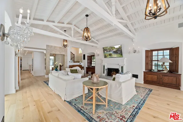 a living room with fireplace furniture and a chandelier