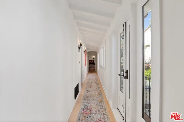 a view of a hallway with wooden floor and closet
