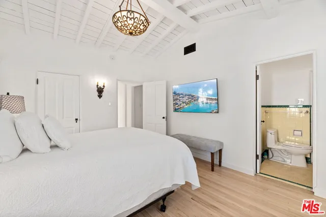 a bedroom with a bed and a table with wooden floor