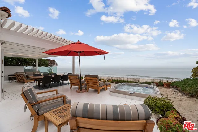 a view of a terrace with furniture and umbrella