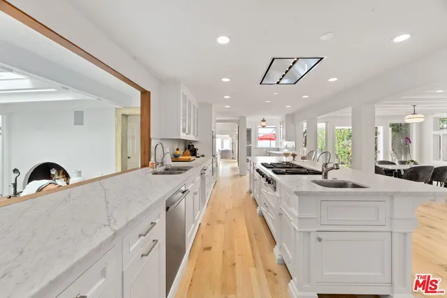 a large kitchen with kitchen island a sink a counter space and stainless steel appliances