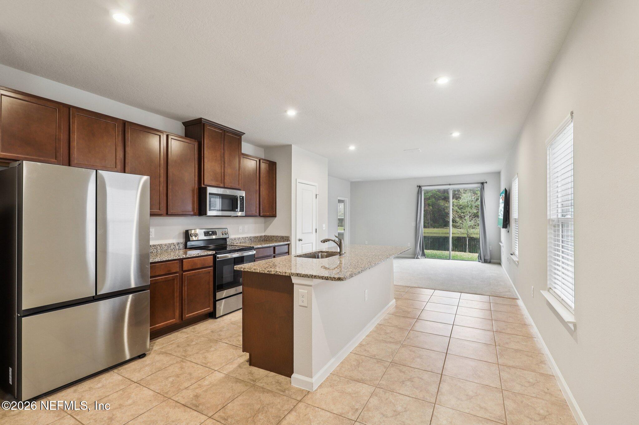 11325 Streamsong Drive Jacksonville, FL 32221 - Photo 11 of 30 a kitchen with stainless steel appliances granite countertop a refrigerator stove top oven and sink