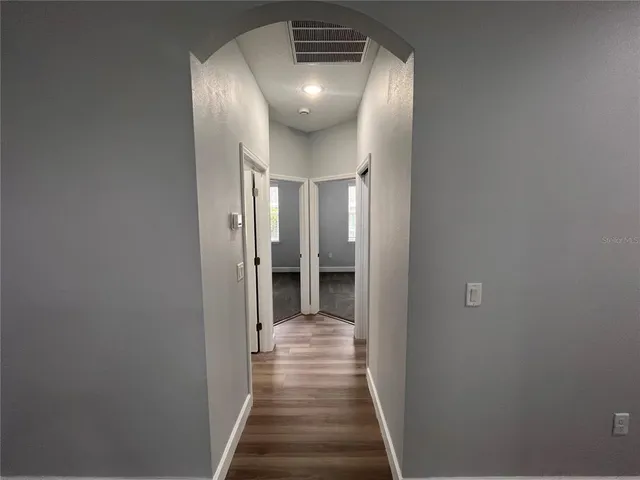a view of a hallway with wooden floor