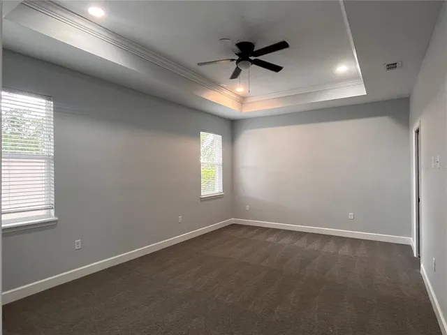 an empty room with a window and a fan