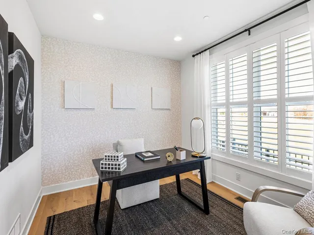 a view of a workspace with furniture and a window