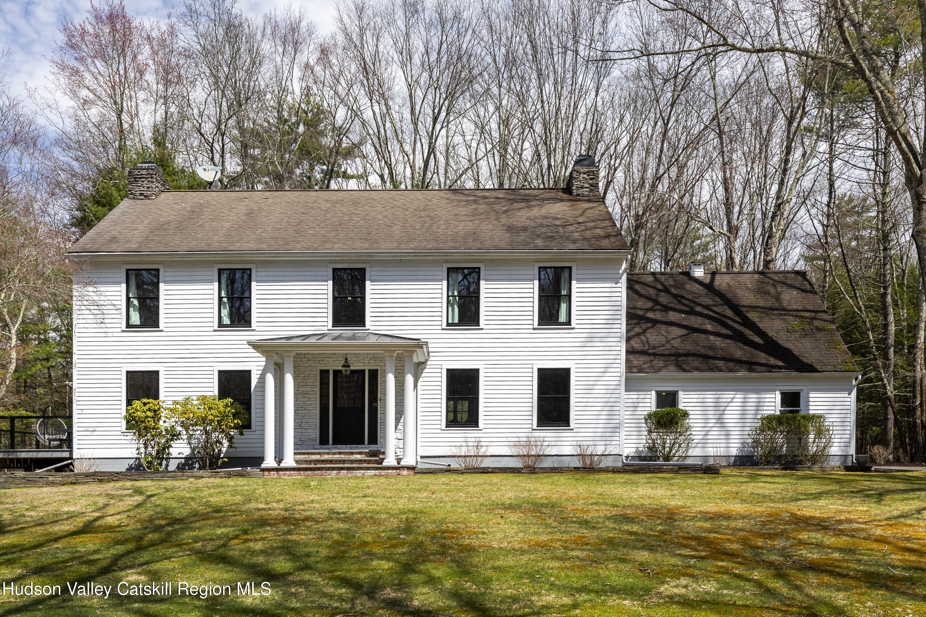 a view of a white house with large trees in front of it