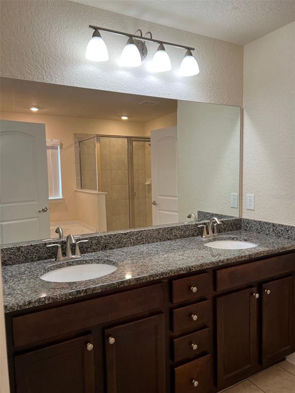 9883 Southwest 55th Ave Road Ocala, FL 34476 - Photo 12 of 30 a bathroom with a granite countertop sink double vanity and a mirror
