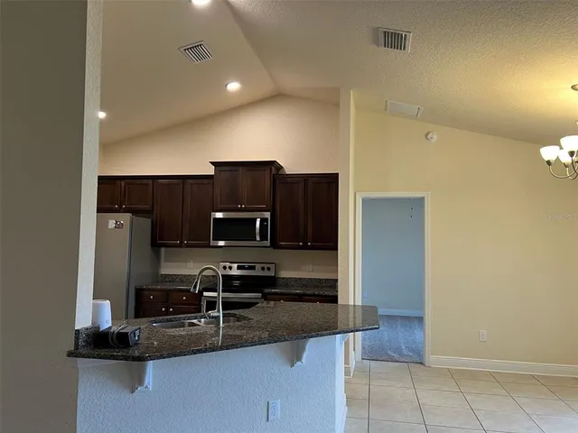 a kitchen with kitchen island stainless steel appliances a refrigerator and a stove top oven
