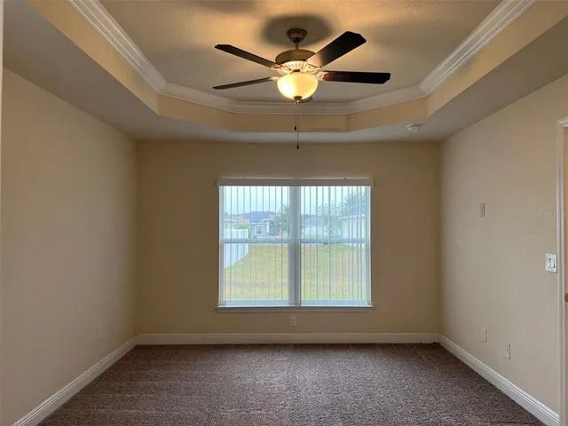 an empty room with ceiling fan and window