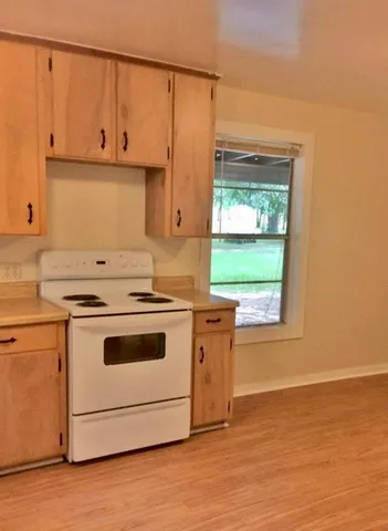 a kitchen with stainless steel appliances white cabinets and a stove top oven