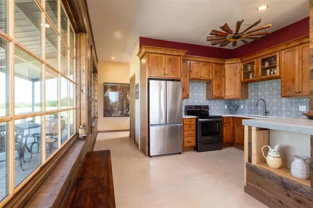 a kitchen with stainless steel appliances granite countertop a refrigerator a sink a stove and white cabinets