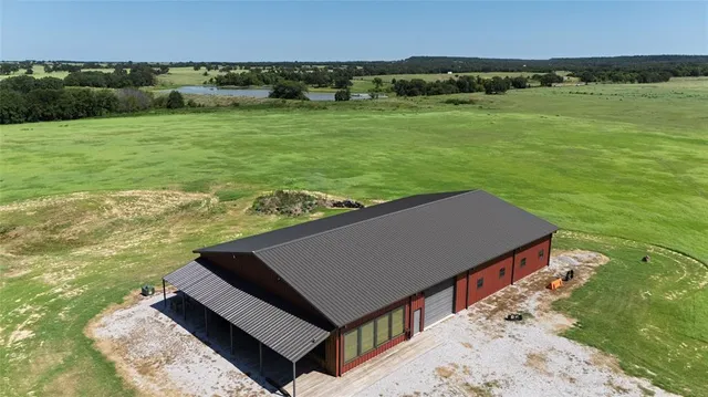 an aerial view of a house with yard and lake view
