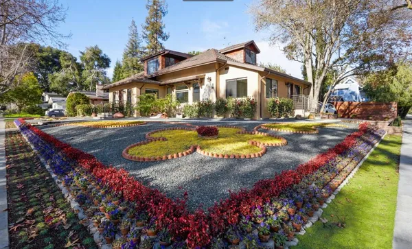 an aerial view of a house with swimming pool and large trees