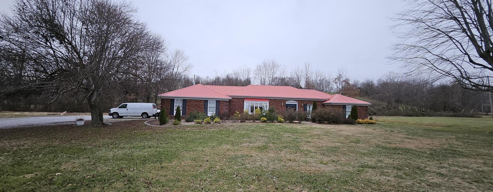 a view of a house with a yard and sitting area