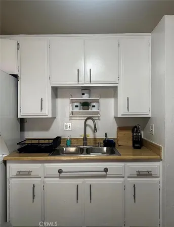 a kitchen with white cabinets and appliances